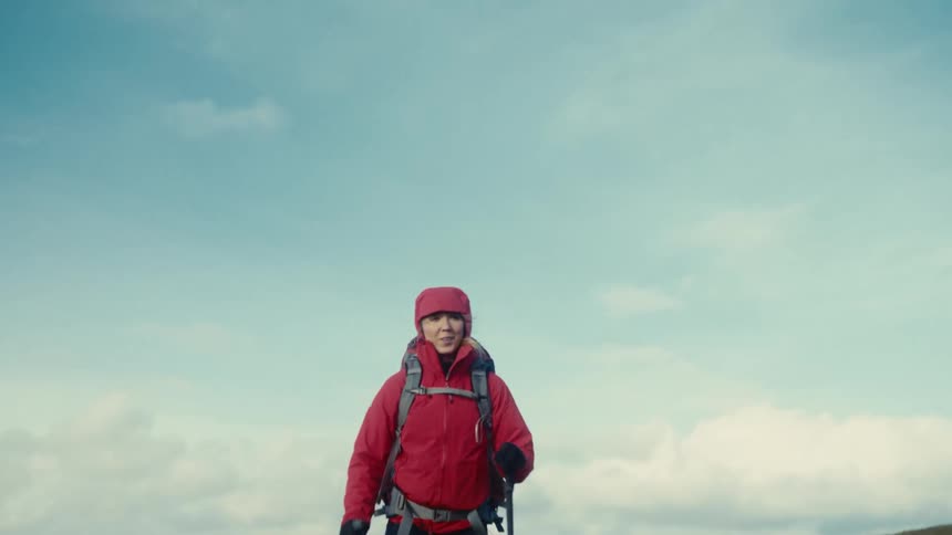 A woman walking outdoors with walking sticks