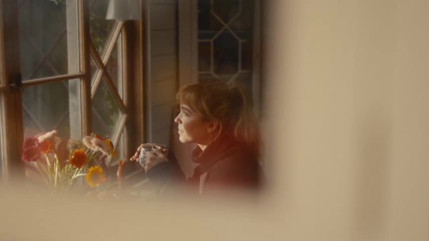 Woman holding a mug while looking out the window