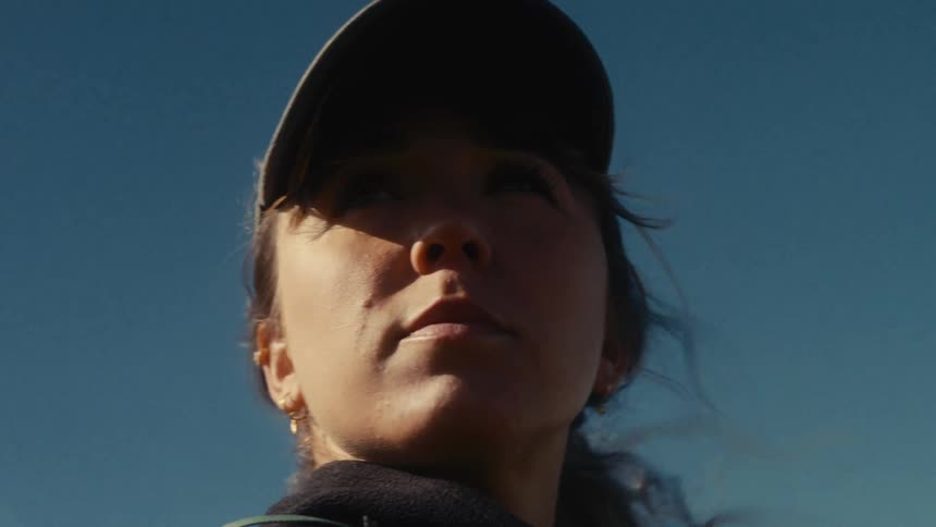 Woman wearing a cap looking to the side under a clear sky