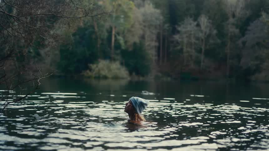 Young woman swimming in a forest river