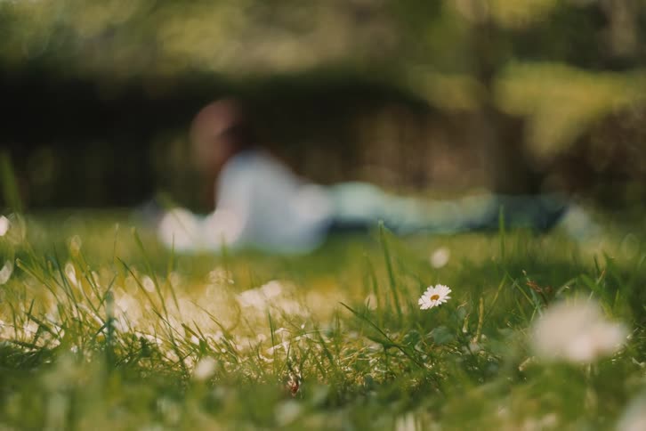 Blurred person lying down on the grass in the background