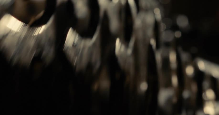 Shot of dark metallic jagged mechanisms moving creating an aggressive and foreboding mood against a blurred dark background