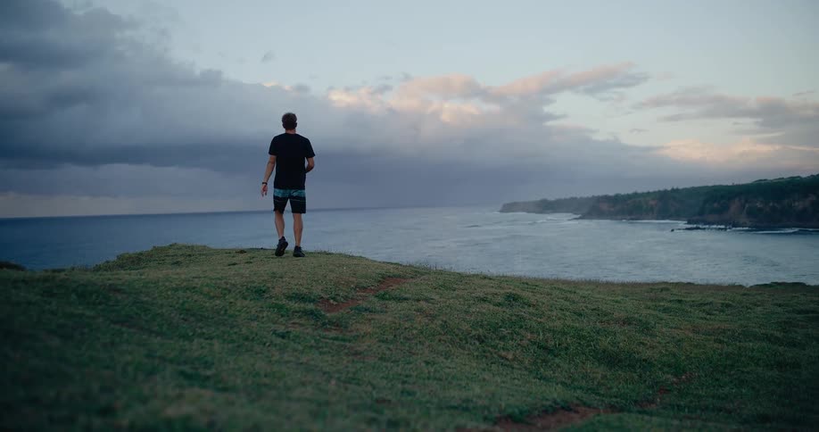 Man running on a grassy area near the sea