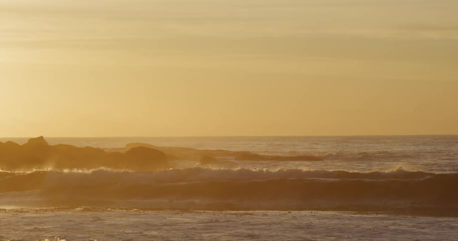 Waves breaking in the sea during sunset