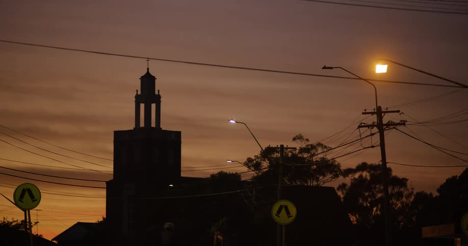 Cyclist and automobiles travel on a neighborhood road at dusk