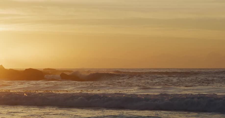 Waves lit by the low sun on the horizon
