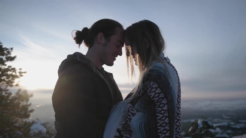 A man and a woman standing outside on a winter day smiling and hugging