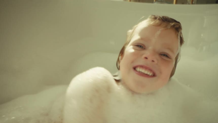 A child taking a bath in a room