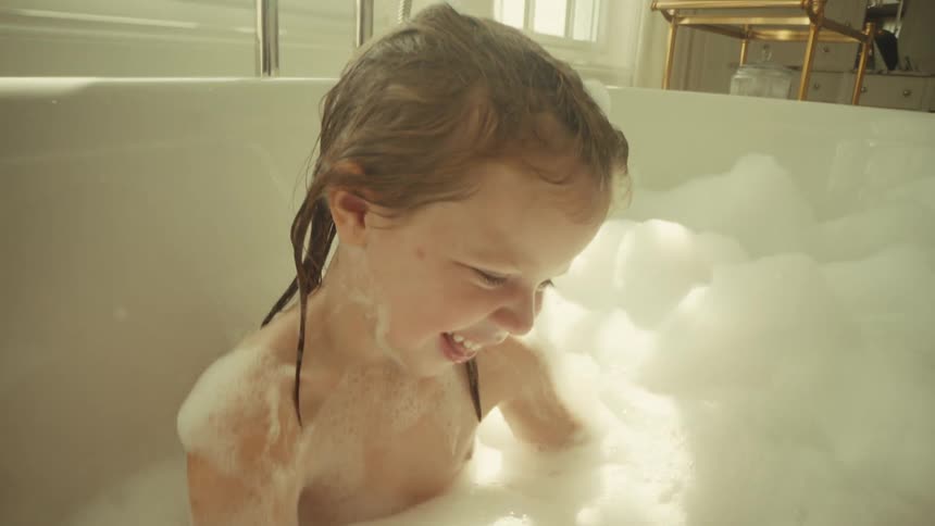 The girl is having fun in the bubble bath