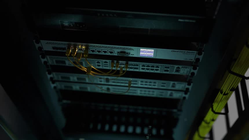 Lights flash on computers in a server room connected by cables