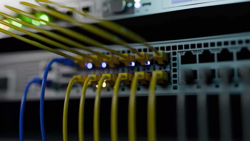 Lights flash on computers in a server room connected by cables