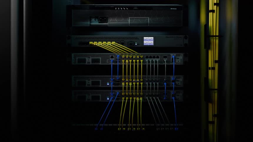Lights flash on computers in a server room connected by cables