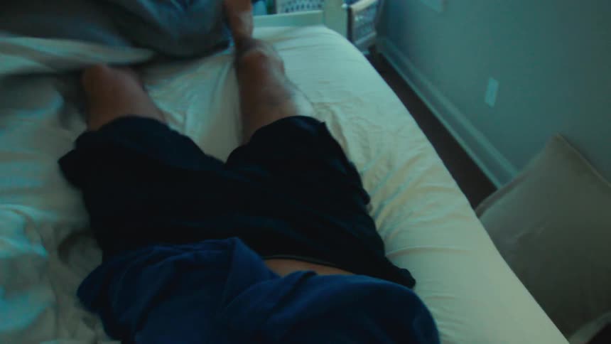 Man stretching in bed and getting up