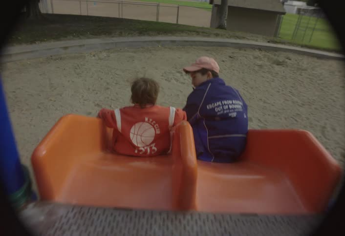 Two kids going down a slide