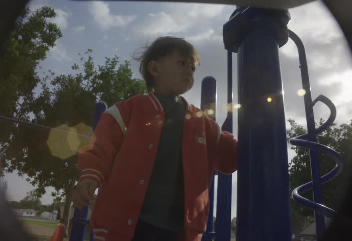 Children standing on a playground platform beside a blue spiral structure