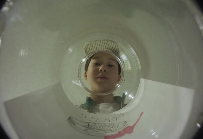 A boy putting money into a jar