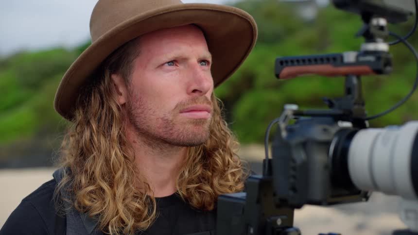 Man standing behind his camera looking ahead