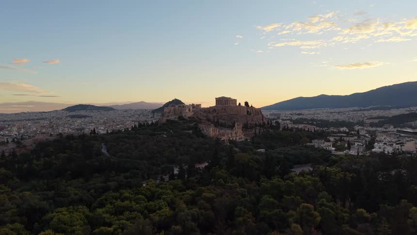 Aerial view of the acropolis of athens surrounded by the city at dusk