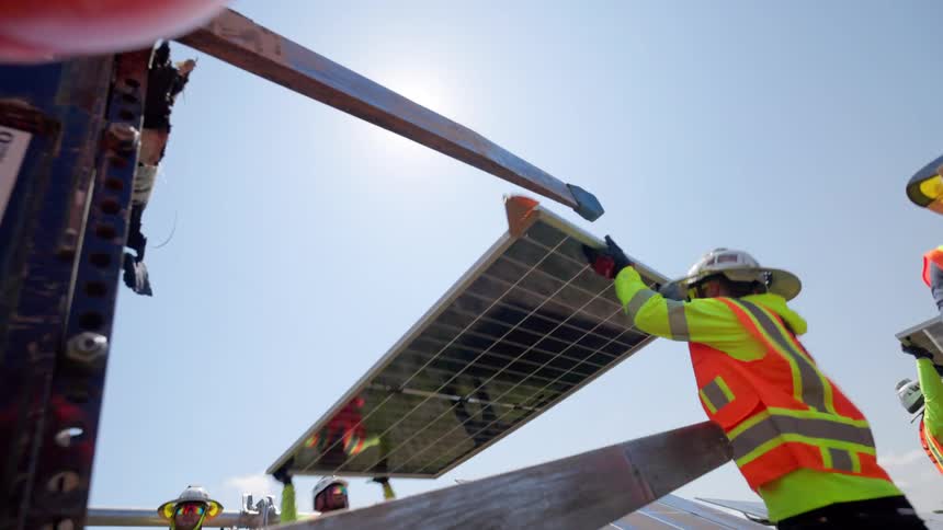 Some employees moving solar panels