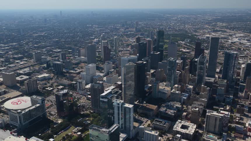 A city skyline with a series of highrise and skyscraper buildings is seen at midday