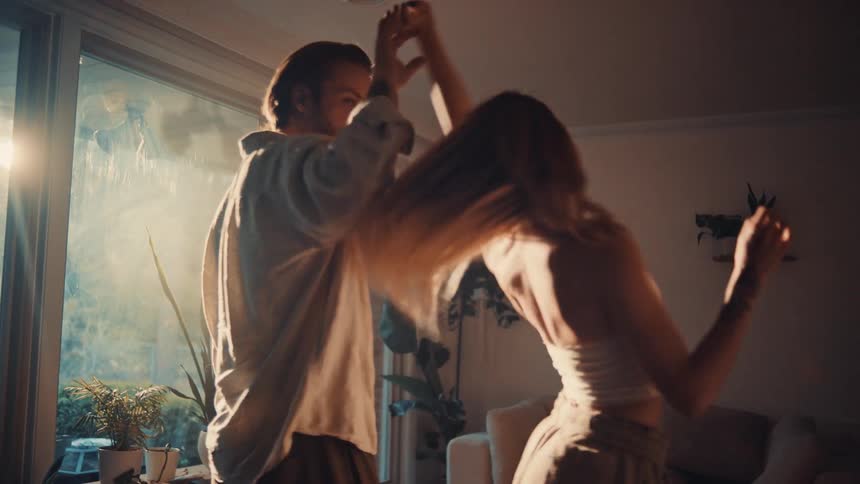 The couple are dancing at home