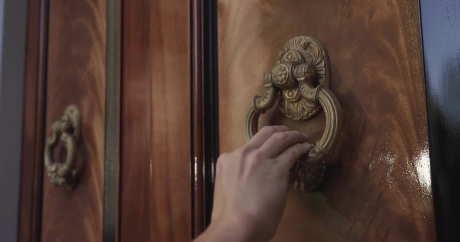 The man knocks on the big door