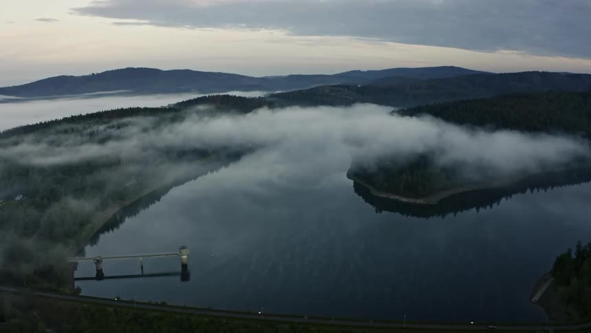 Clouds hanging over forested mountains along the coast