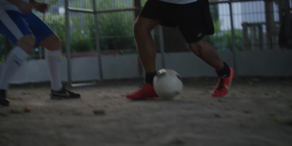 A person playing soccer quickly dribbles the ball past other players