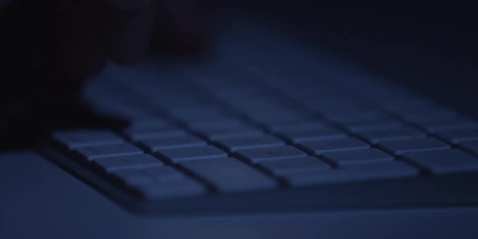 The person is typing on the white keyboard