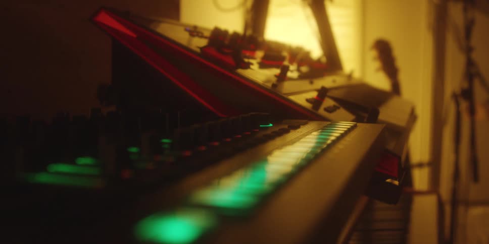 A room contains a guitar and multiple electronic keyboards