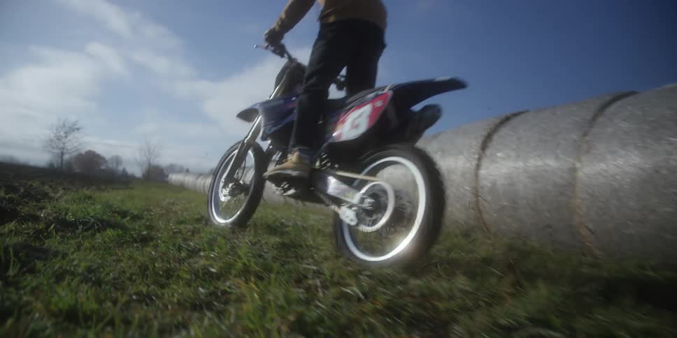 The dirt bike speeds through the grass
