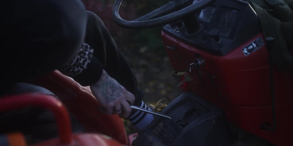 Close up of a person driving an agricultural tractor outdoors in a rural area during daytime