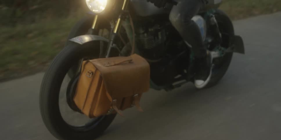 A bag is attached to the wheel of the moving motorcycle