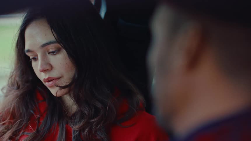 Woman inside a car looks at the person beside her