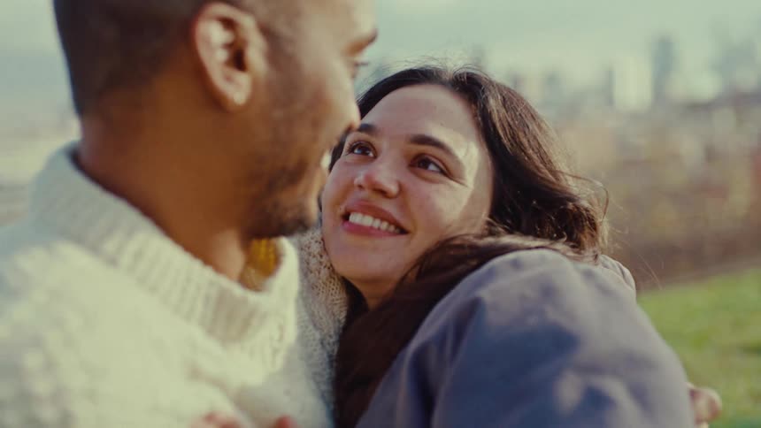 A man and woman hugging each other outdoors
