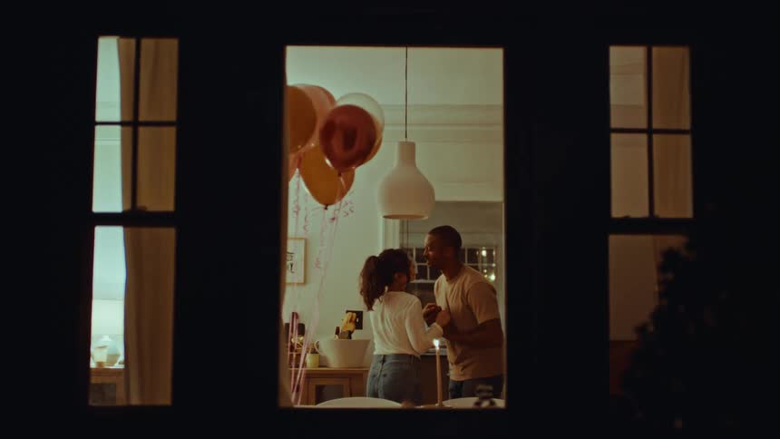 The couple are dancing together inside at night