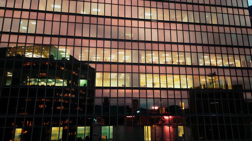 Close up of a high rise building covered with reflective glass in a metropolitan city at sunset