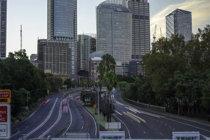 Traffic moves on the road in and out of downtown with buildings in the distance