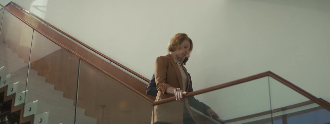 Two coworkers walking down stairs together