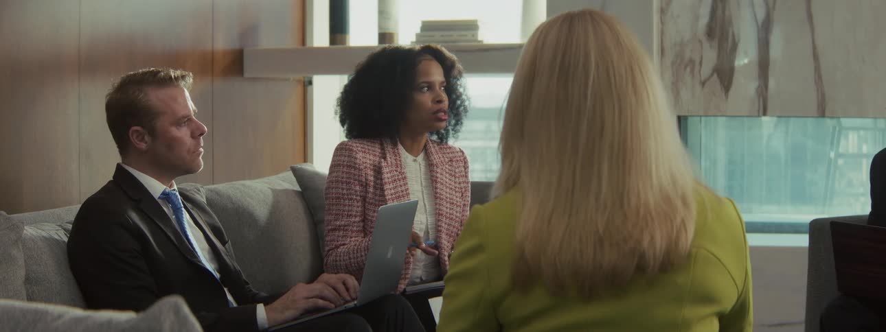 A group of people sitting in an office space have a meeting
