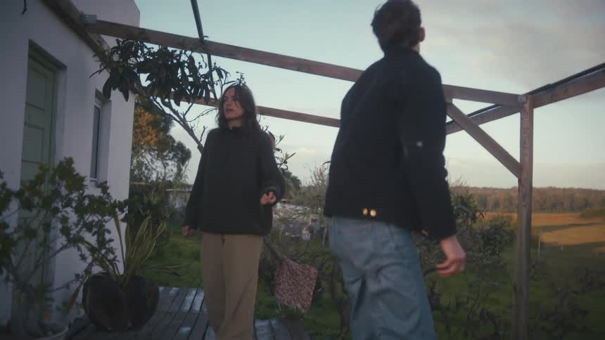 A man and woman talking outdoors in a garden