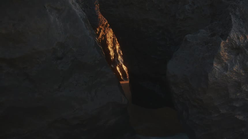 Crevice between rocks showing golden light in the background