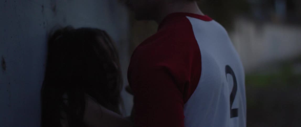 A man pushes a struggling woman up against a wall