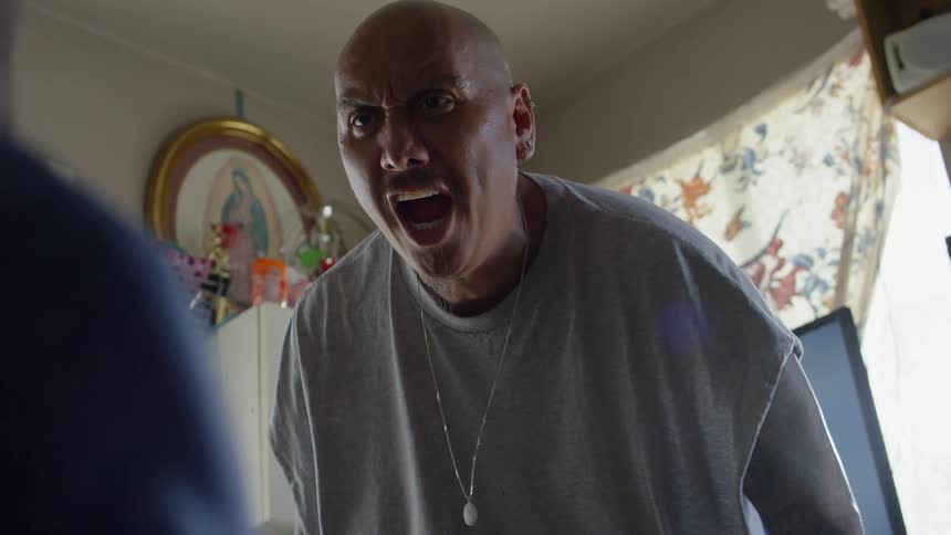 A man shouts angrily at another person