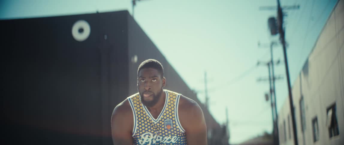 A man shoots a basketball in an alley