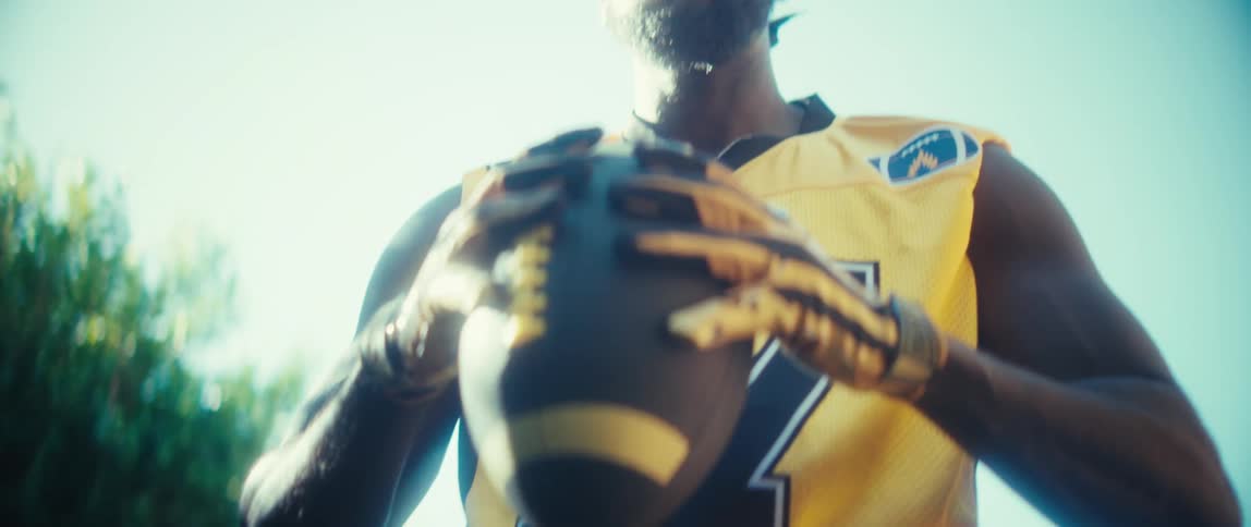The man lifts the football and throws it