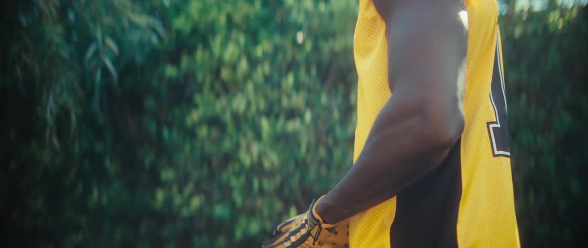 Man wearing gloves playing american football outdoors