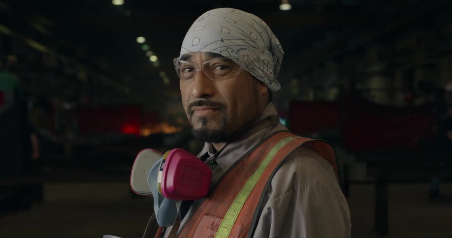 Man wearing a vest and goggles smiles