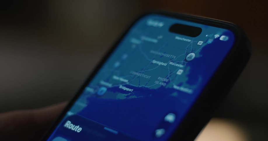 A persons hand holds an iphone while scrolling through a map