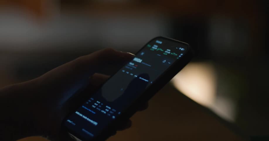 Woman examines the plot of a stock on a smartphone